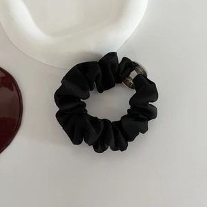 Chouchou en satin noir élastique avec breloque en métal argenté et texture plissée
