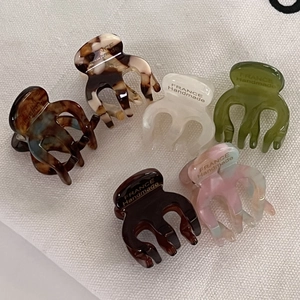 Close-up of 6 colorful acetate mini hair claws in marble and tortoiseshell patterns