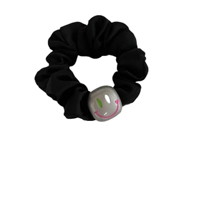Chouchou en tissu noir élastique avec un cube décoratif gris et un smiley rose vif
