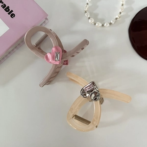 Detail of pink and yellow heart hair claws with rectangular crystals in a set