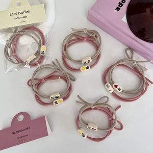 Élastiques à cheveux roses et beige avec perles cubiques dans un emballage artisanal