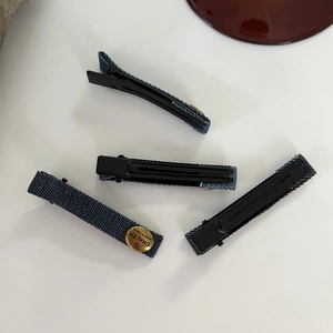 Set of four denim fabric snap hair clips with a vintage gold metal logo detail