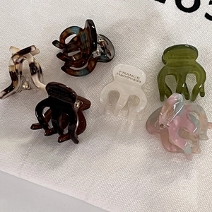 Detail of five handmade acetate hair claws with marble and tortoiseshell patterns