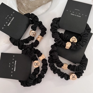 Minimalist black scrunchies set with cute metal bear and rabbit charms on white background