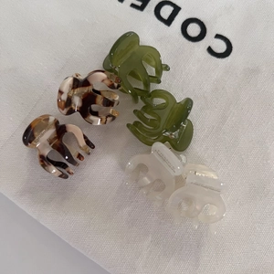 Macro detail of handmade mini acetate hair claws in tortoiseshell and ivory finishes