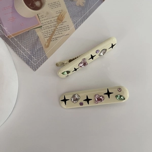 Set de barrettes Y2K crème avec strass colorés et motifs d'étoiles noires stylées