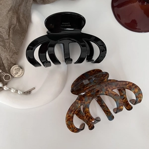 Dettaglio molletta per capelli in acetato fatta a mano con logo dorato France handmade