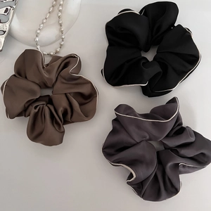 Detailed view of satin scrunchies in coffee black and grey with contrast white edges