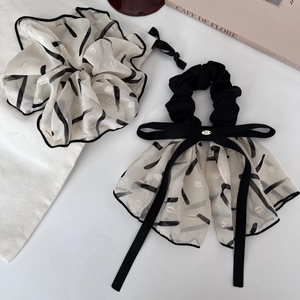 Detailed view of chiffon hair scrunchies with black and white ink print and long ribbons
