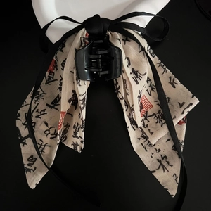Detail view of New Chinese style bow hair claw clip with ink calligraphy print and silk ribbon