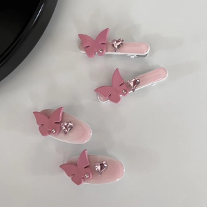 Lot de quatre barrettes papillon en strass roses avec des pierres en forme de cœur