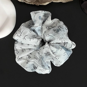Detailed view of ink wash calligraphy print on fluffy chiffon scrunchie with ribbons