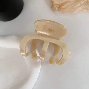Close-up of cream acetate hair claw clip featuring France handmade lettering detail