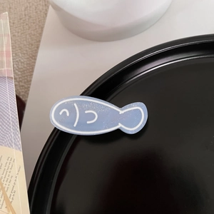 Makro-Detail der niedlichen hellblauen Fisch-Haarklammer mit glitzerndem Acryl-Finish