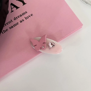 Gros plan sur la barrette papillon en strass rose avec cristal en cœur et fini acétate