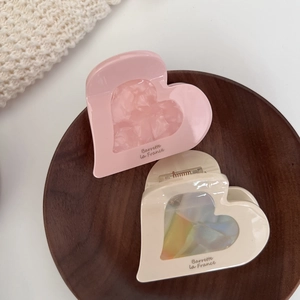 Pinces à cheveux en forme de cœur rose et crème en acétate sur plateau en bois élégant