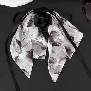 Detail of elegant black ribbon bow hair clip with ink painting style chiffon fabric
