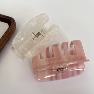 Elegant ivory and pale pink acetate hair claws with premium marble texture on white background