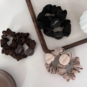Three-piece satin scrunchies set in neutral colors with Lucky engraved heart charms