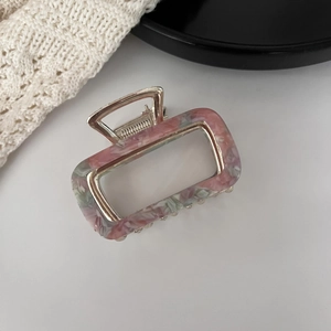 Detail of vintage square acetate hair claw clip with golden alloy frame and marble pattern