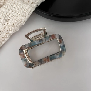 Macro shot of marble textured acetate hair claw clip with strong silver metal spring