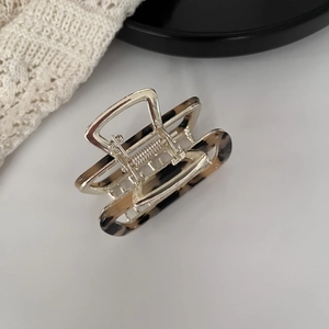 Detail view of the tortoise shell square hair claw clip with silver metal spring mechanism