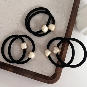 Détail d'élastiques à cheveux noirs à haute élasticité avec breloques trèfle en perle