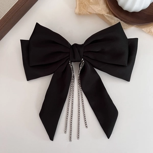Detail of black satin bow hair clip featuring sparkling rhinestone fringe tassels decoration