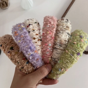 Detailed view of six colorful knitted fuzzy headbands in brown, purple, white, and green