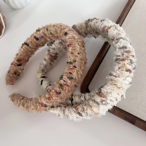 Detailed texture of thick knit headband in brown and beige curly yarn material