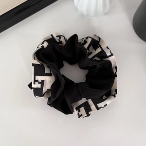 Chouchou élégant en satin noir et blanc avec motif géométrique pour queue de cheval