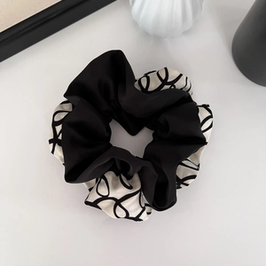 Chouchou élégant en satin noir et blanc avec imprimé abstrait sur fond blanc