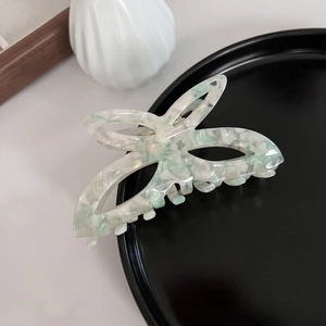 Vue détaillée d'une pince à cheveux papillon en acétate marbré vert menthe élégante