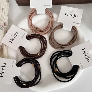 Detailed view of elastic hair bands in assorted colors with stylish bronze oval beads