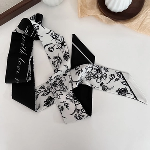 Close-up of black and white silk twilly scarf with floral print and with love text