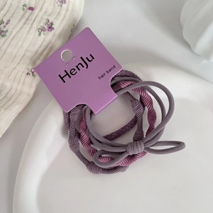 Detailed view of elastic purple hair bands with textured finish on a purple display card