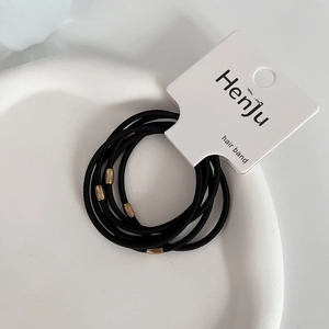 Detailed close-up of 6 durable black elastic hair bands with golden beads on card