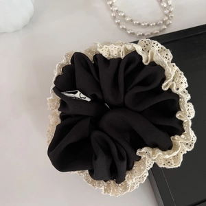 French retro black scrunchie with cream lace edges and pearls on a white background