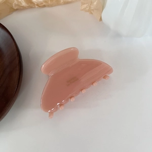 Close-up of pink acetate hair claw clip with Barrette La France text engraving
