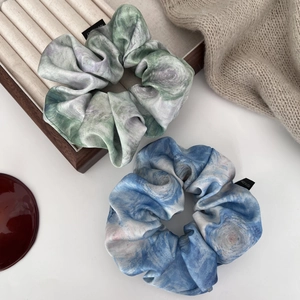 Close-up of abstract oil painting style satin scrunchies with elegant silk-like texture