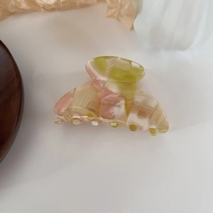 Close-up of pink and green marbled acetate hair claw clip with Barrette la France text