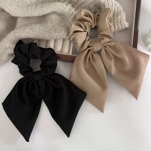 Détail de grands chouchous à nœud papillon en noir et kaki avec texture de tissu