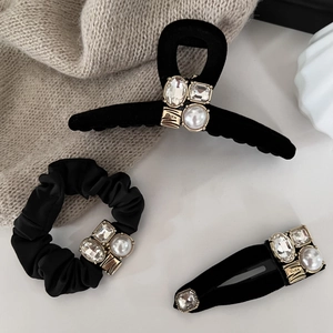 Detail of black velvet hair set with gold hardware, rhinestones and elegant pearls