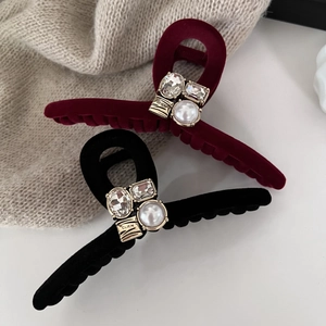 Detail of velvet hair claws with sparkling crystals and a white pearl in black and burgundy