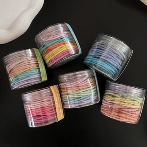 Farbenfrohe, hochelastische Haargummis in transparenten Dosen mit Macaron-Farben