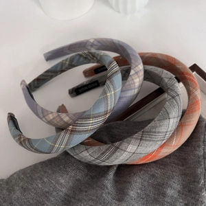 Close-up of handmade plaid padded headbands in blue, grey, orange, and purple fabric