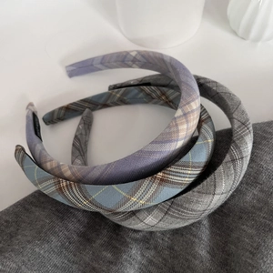 Chic plaid padded headbands in grey and purple on textured knit fabric backdrop