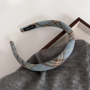 Detail of light blue plaid headband showing the handmade label and fabric texture