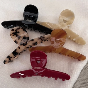 Macro detail of high-quality acetate hair claws in assorted colors with gold branding