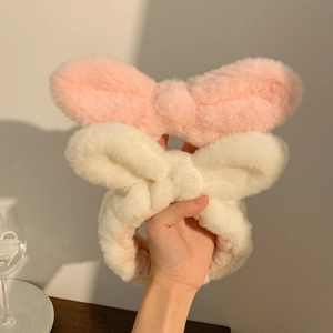 Close-up of soft pink and white plush bow headbands for face washing and skincare